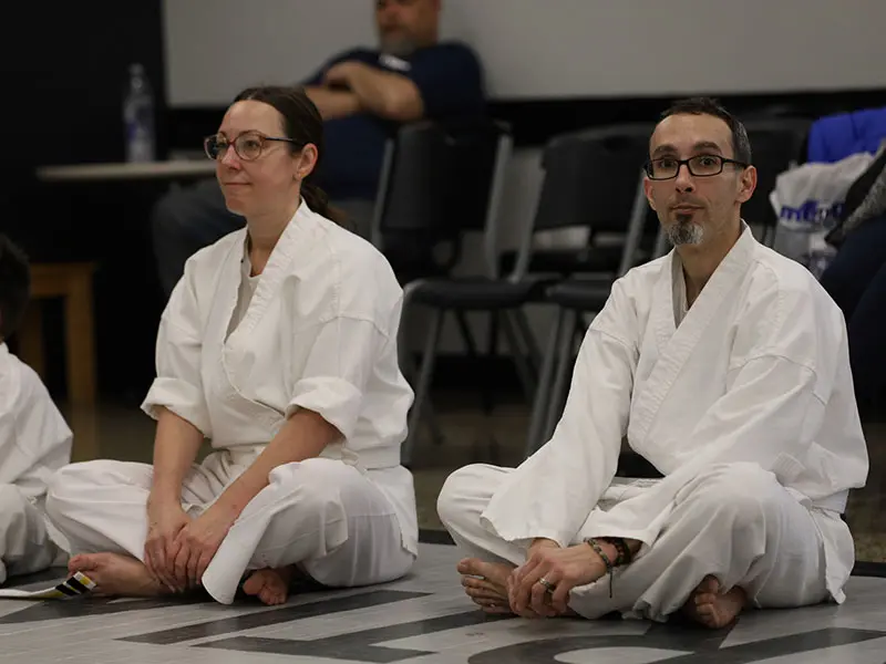 Adult martial arts students relaxing and socializing after training in Holland gym